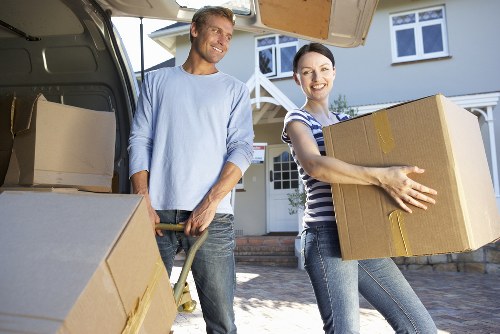 Professional movers carrying furniture through a Kennington property